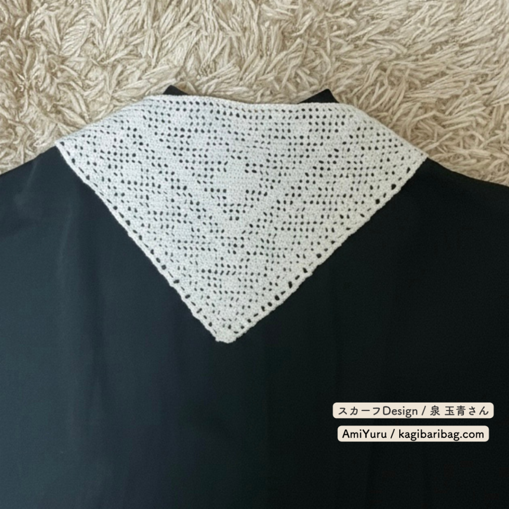 ウール糸を使って、かぎ針で編む方眼編みの三角スカーフを黒色の服と合わせた画像。