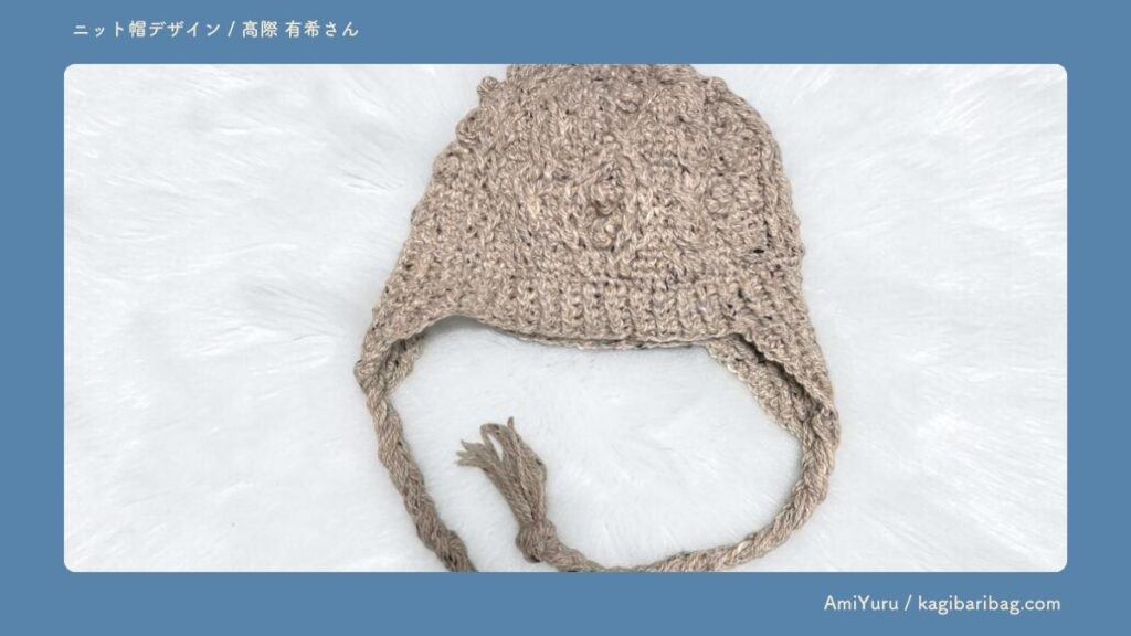 かぎ針で編む、アラン模様のニット帽。
耳当て付き・三つ編みの紐付きの冬の帽子。